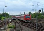 Vorbei an einem pausierenden AKN-Triebwagen verlässt ein Zug der Hamburger S-Bahnlinie 3 die Station  Eidelstedt .