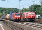 DE13 der HGK auf Solofahrt begegnet 185 018-9 mit gemischtem Gterzug in Kln-West. Rechts am Rand die geparkte ES 64 U2-027 der Wiener Lokalbahnen. Aufgenommen am 13/06/2009.