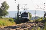 185 566-7 legt sich mit ihrem Containerzug in Richtung Süden kurz vor Wehretal-Reichensachsen in den Gleisbogen.