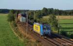 185 518-8 TX Logistik hat am 1.08.12 einen langen Containerzug am Haken und passiert hier gerade Ramelsoh Richtung Bremen.