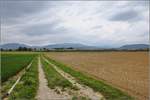 Bahn im Elsass. Bild mit dem Menschenfresserberg alias Hartmannsweilerkopf links im Bild, der gerade aktuell ein Thema der deutsch-franzsischen Beziehungen war, siehe auch nhere Beschreibung bei Bild 1051431. Rechts im Hintergrund mit dem groen Belchen der hchste Berg der Vogesen. Davor schiebt Sybic 26153 einen TER Richtung Mlhausen. Raedersheim, Oktober 2017.