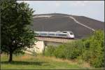 Vorne idylische Wiese, hinten Müllberg -     Nachschuss auf einen TGV Stuttgart - Paris in der  Müllkippenkurve .