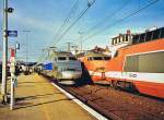 In Bourg-en-Bresse begegnet ein TGV in aktueller Lackierung einer Doppeleinehit Orange.