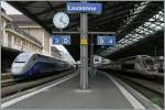 TGV Bahnhof Lausanne: Während rechts im Bild der TGV Lyria auf seine Abfahrtszeit nach Paris um 12.24 wartet, steht (ohne dass ich den Grund dafür kenne) auf Gleis zwei ein SNCF Doppelstock