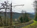 Frankreich, Languedoc, Hérault, La Bastide (kurz vor der Einfahrt in den Bahnhof von Bédarieux). Auf der Strecke Béziers-Neussargues(-Clermont-Ferrand) verkehren nur noch wenige Züge. Die 1500 V Gleichstrom Elektrifizierung des Typs  caténaire inclinée  wird trotz ihres Zustandes wohl kaum erneuert. 09.02.2014