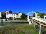 Frankreich, Languedoc, Gard, Aigues-Mortes. Die Drehbrücke über den Kanal auf der Eisenbahnlinie (Nîmes -) Saint-Césaire - Aigues-Mortes - le Grau-du-Roi. Nun kann der Triebwagen vom Grau du Roi nach Nîmes über den Canal du Rhône à Sète fahren. Fotografiert beim Kreisverkehr, den die Bahn hier durchquert (siehe Karte). 13.09.2014