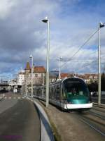 CTS Tram-1015 (Eurotram) unterwegs auf der Linie B (Baggersee).
Auf der Eisenbahnbrücke befindet sich der Haltepunkt Krimmeri-Meinau und dahinter grüßt das Straßburger Münster.

2012-12-30 Strasbourg Krimmeri