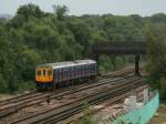 Ein elektrischer Triebzug der Reihe  Class 319  hat vor wenigen Augenblicken den Flughafenbahnhof von London-Gatwick verlassen und fhrt Richtung Sden zur Kste.