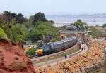 Blick vom ideal gelegenen Fotohügel auf einen Teil der Station Dawlish Warren. Im Hintergrund wartet der Regionalzug nach Paignton, dieser wurde soeben vom Hochgeschwindigkeitszug nach Penzance überholt. Dawlish Warren, 17.5.2022