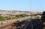 Währenddem ein 12-teiliger Thameslink Class 700 aus dem Bahnhof Brighton fährt, durchquert ein Class 313 als Southern Brighton - Seaford am 3. August 2018 den London Road Viadukt in Brighton.