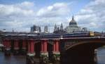 Ein Triebzug der Class 319 überquert im Sommer 1992 die Blackfriars Railway Bridge in London. Im Vorgrund die Reste der älteren, 1864 errichteten Brücke, die bis 1971 ebenfalls für den Zugverkehr genutzt und 1984 bis auf die Pfeiler abgerissen wurde, im Hintergrund die St. Pauls Cathedral.