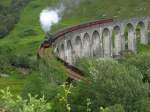  The Jacobite  als Mittagszug aus Richtung Fort William in Richtung Mallaig überquert das Glenfinnan-Viadukt und wird direkt dahinter mit dem zurückkehrenden Morgenzug im Bahnhof Glenfinnan