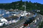 7827 erreicht den Bahnhof Kingswear, 30.08.2010. Kingswear ist ein kleiner Ort, die Strecke von Paignton wurde gebaut, um das am gegenberliegenden Fjordufer gelegene Dartmouth anzubinden. Technisch war die Strecke nach Kingswear wesentlich einfacher zu realisieren als Dartmout direkt anzubinden, so mussten die Reisenden stets die Fhre am Bahnhof Kingswear nutzen. Heute wird die Strecke von der Paignton and Dartmouth Steam Railway betrieben, im Sommer verkehren bis zu acht Zugpaare.