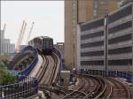 Über die Kuppe -

Ein Zug der Docklands Light Railway (DLR) verlässt die Station Westferry in Richtung Canary Wharf und Lewisham. 

Ursprünglich war das Gleisdreieck zwischen den Stationen Westferry, West India Quay und Poplar niveaugleich. Mit dichter werdendem Verkehr musste es kreuzungsfrei ausgebaut werden. Dabei entstand dieses Brückenbauwerk auf der linken Seite. Zuerst geht es nach oben und der Abzweig nach Poplar wird überquert, dann senkt sich das Gleis wieder nach unten die Gleise West India Quay - Poplar werden unterquert.

Auf der Karte kann die Gleisführung gut nachvollzogen werden, auch das alte einfache Gleisdreieck nördlich der Station West India Quay.

Im Hintergrund die gelben Stahlstützen der Multifunktionsarena The O2, früher Millenium Dome genannt. Die Bebauung rechts ist wenig ansprechend.

29.06.2015 (M)