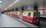 Wagen 101 der Glasgow Subway erhielt 2016 aus Anlass des 120-jährigen Jubiläums der Glasgow Subway eine Sonderlackierung ähnlich der ersten Kabelbahnzüge. Gut zu sehen die Krümmung der Haltestelle, welche die Züge beim Bremsen und Beschleunigen unterstützt.