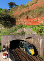 Ein GWR-Hochgeschwindigkeitszug rast aus dem Tunnel in der Nähe des Bahnhofs Dawlish. Das Foto wurde von einer Fussgängerüberführung aus gemacht. Dawlish, 17.5.2022
