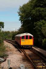 Ein Zug der Island Line nach Shanklin bei der Einf. Smallbrook Junction am 04.09.2015, im Hintergrund die Stadt Ryde. Auf Grund eines Tunnels bei Ryde mit kleinem Lichtraumprofil kommen hier ehemalige Züge der Londoner Underground, Typ 1938 Tube Stock, zum Einsatz. Die Strecke wurde 2007 durch South West Trains übernommen.