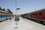 Zwei Züge im Bahnhof Teheran. Der rechte Zug mit dem Fahrziel Mashad besteht aus ex DB Regio-Waggons, die großteils noch in verkehrsrot lackiert sind. 