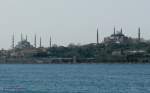 istanbul-banliyo-trenleri-vorortbahn Blick vom Meer auf die Strecke zum Bahnhof Sirkeci mit der Hagia-Sophia (rechts) und der Sultan-Ahmet-Camii (Blaue Moschee) links im Bild.
Auf der Strecke sind zwei Triebz�ge der betagten Reihe E8000 des Istanbuler Vorortverkehrs in Doppeltraktion unterwegs.
Die Strecke umrundet hier die Halbinsel, mit dem Berg auf dem der Topkapi-Palast steht.
Nach Fertigstellung des Marmaray-Projekts mit der Bosporusquerung wird sie durch diese  unterirdische Strecke ersetzt werden.
11.04.09
