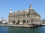 istanbul-haydarpascha Der Kopfbahnhof Haydarpascha (Haydarpaşa) ist Endpunkt der Eisenbahnen aus Anatolien und liegt direkt am Bosporus auf der asiatischen Seite Istanbuls. Die Verbindung zur europ�ischen Seite Istanbuls erfolgt mit den Bosporusf�hren. Nach Fertigstellung des Marmaray-Projekts (Bahn-Untertunnelung des Bosporus) wird er seine zentrale Rolle aber verlieren. 
Nach den bisherigen Planungen (wogegen es aber auch Widerstand gibt) werden dann hier keine Personenz�ge mehr verkehren.


Der Bahnhof wurde von 1906-1908 nach Pl�nen der deutschen Architekten Otto Ritter und Helmuth Conu von der Firma Philipp Holzmann gebaut. Den Namen erhielt er zu Ehren eines ber�hmten Paschas, der unter Selim III. dem Hof diente.

11.04.09


