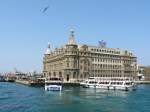 istanbul-haydarpascha Der Kopfbahnhof Haydarpascha (Haydarpaşa) ist Endpunkt der Eisenbahnen aus Anatolien und liegt direkt am Bosporus auf der asiatischen Seite Istanbuls. Die Verbindung zur europ�ischen Seite Istanbuls erfolgt mit den Bosporusf�hren. Nach Fertigstellung des Marmaray-Projekts (Bahn-Untertunnelung des Bosporus) wird er seine zentrale Rolle aber verlieren. 
Nach den bisherigen Planungen (wogegen es aber auch Widerstand gibt) werden dann hier keine Personenz�ge mehr verkehren.


Der Bahnhof wurde von 1906-1908 nach Pl�nen der deutschen Architekten Otto Ritter und Helmuth Conu von der Firma Philipp Holzmann gebaut. Den Namen erhielt er zu Ehren eines ber�hmten Paschas, der unter Selim III. dem Hof diente.

11.04.09


