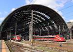 Zwei verschiedene Hochgeschwindigkeitszüge 'Frecciarossa' (Roter Pfeil) warten in Milano Centrale unter dem imposanten Hallendach auf die Abfahrt. Milano, 25.4.2023