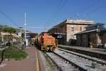 145 251-4 zieht am 30.10.2017 einen Gleisbauzug in den Bahnhof von Alassio.