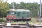 Eine alte italienische Dieselok D 345 100 steht abgestellt in Alessandria(I) bei Sonne und Wolken.