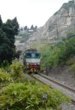 E 424 032 zeigt sich am 21.04.06 kurz mit ihrem Regionalzug auf ihrer Fahrt von Catania nach Messina am Fue der malerisch gelegenen Stadt Taormina um kurz darauf im Tunnel von Mazzaro zu