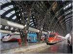 In Milano Centrale warten ein FS Trenitalia ETR 400  Frecciarossa 1000  und durch die mächtige Konstruktion der Bahnhofshalle etwas verdeckt ein  Freccia Bianca  auf die Abfahrt.
16. Nov. 2017