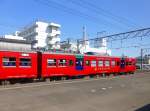Serie 713: Der strahlend rote motorisierte Endwagen des Zweiwagenzugs 713-2 in Minami Miyazaki, 3.August 2013. 