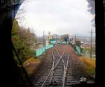 Die Asa Kaigan-Bahn - Einfahrt in die Endstation Kaifu von Süden her. Im Bahnhof wartet bereits der Triebwagen 1509 von JR Shikoku für die Weiterfahrt nach Tokushima. Dahinter ist der kurioseste Tunnel in ganz Japan zu sehen: Der Tunnel steht noch, doch der Berg, durch den er einst führte, ist abgetragen worden, um Platz für Häuserbauten zu schaffen! 3.April 2015.  