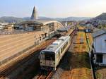 Ibara-Bahn im ländlichen Hinterland von Okayama. Triebwagen 355-02 verlässt gerade die eigenwillig gestaltete Station Ibara, 9.November 2017. Die Bahn besitzt 9 solche Triebwagen mit einigen Längsbänken und recht einfachen Sitzgruppen (ein zehnter solcher Wagen ist nach Myanmar gegangen), zwei neuere Triebwagen mit sehr bequemen Sitzen, und einen Triebwagen für Sonderfahrten. 