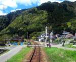 Nagaragawa Eisenbahn: Fahrt im Triebwagen 301 am Tag des Frhlingsfestes durchs Tal. Vor dem Hintergrund frischgrner Wlder strahlt die Fahne des rtlichen Schreins und wehen die Karpfenwimpel der Bauernhuser im Wind. Bei Yasaka, 19.April 2008.