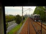 Der Hankyû-Konzern - Die Züge der 1980er Jahre: Serie 7000. Der modernisierte 8-Wagenzug 7320 (Endwagen 7400) erreicht am Rande von Osaka bald die Endstation Kita Senri. Diese Züge fahren auch auf die U-Bahn Sakaisuji-Linie ein. 28.September 2009. (Aufnahme durch die verglaste Führerstandrückwand eines Gegenzugs)