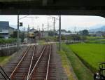 Iyo-Bahn: Im Zug 3502 auf der Yokogawara-Linie bald nach Verlassen der Stadt. Die Reisfelder sind noch grün, also noch nicht ganz zur Ernte bereit. Es kreuzt ein alter Zug (Serie 800, ehemals Keiô-Konzern, Tôkyô). Minara, 18.September 2009. 
