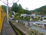 Seibu-Konzern, Chichibu-Linie: Beim Aufstieg in die Berge gelangt der S-Bahnzug 2069 in ein typisches Bergdorf mit Tempelanlage und (unter dem kleinen Dach in Bildmitte) einer grossen Tempelglocke,