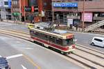 Strassenbahn Nagasaki, Serie 1700: Bis heute werden neue Wagen nur tröpfchenweise beschafft, und mit möglichst vielen Gebrauchtteilen. Die Serie 1700 besteht aus den beiden Wagen 1701 und 1702 mit relativ schwachen Motoren (2 x 38 kW) aus dem Jahr 1999. Ausser Wagenkasten und Inneneinrichtung stammen viele Teile aus alten Fahrzeugen. Man kann knapp auch die alten Fahrkontroller im Führerstand erkennen. Bild: Wagen 1702 beim Bahnhof Nagasaki, 1.April 2018