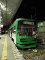 Wagen 3955 (Green Liner) der Hiroshima Strassenbahn in der Haltestelle  Hiroden-Nishi-Hiroshima  auf Gleis 1 am 09.11.2010. Dieser Zug fhrt vier Mal tglich von Nishi-Hiroshima nach Miyajima-guchi auf der Hiroden Miyajima Line. Diese Strecke ist nicht Teil der  Inner City , verkehrt auf einem eigenen Gleiskrper und fllt auch nicht unter die  150Yen fr eine Fahrt, egal wie weit -Regel.