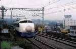 Shinkansen Serie 0: Am 30.November endete der Plan-Einsatz der Züge Serie 0. Diese Züge der Tôkaidô-Linie (Tokyo-Osaka in 2 Std.52 Min.), mit denen 1964 die erste Hochgeschwindigkeitsbahn der Welt eröffnet wurde, haben wie nichts anderes das japanische Wirtschaftswachstum symbolisiert; nun wird am 14.Dezember die allerletzte Sonderfahrt erfolgen. Bis 1986 wurden 3216 Wagen gebaut. Hier fährt ein Zug mit Endwagen 21-87 in Mishima ein, 3.Juli 1979.