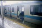 Serie 209: Der Taifun wütet heftig, die Fahrleitungen sind heruntergerissen, nichts mehr fährt. Ein Zug der Keihin Tôhoku-Linie steht verlassen in Sakuragichô, ein zerrissener Schirm liegt im Eingang. 22.September 1996.  KEIHIN-TÔHOKU-LINIE 