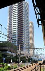 Monströse Gebäude in Tokyo: Immer mehr Menschen wohnen in sog. Tower Mansions, also  Turm-Wohnblocks , wie hier in Musashi Kosugi ausserhalb von Tokyo. Einfahrt des Zuges 233-8022 des Nambu-Linie. 25.April 2022 