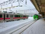 Serie 789 von JR-Hokkaidô, Zug 789-102 wartet in Aomori auf Abfahrt unter das Meer nach Hokkaidô. Daneben Regionalzug von JR-Ostjapan Nr.701-1, in Aomori am 12.Februar 2013. Bald gehören solche Szenen der Vergangenheit, und man braust dann mit dem Shinkansen direkt von Tokyo nach Hokkaidô. 