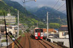 JR Kyûshû Serie 815: Zug 815 Nr.16 kommt in der Bucht von Beppu entgegen.