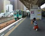 Lokalverkehr auf Shikoku - der Nordosten: Kaum ein Land hat so viele Eisenbahnfreunde wie Japan, ob junge beim Fotografieren oder Aeltere beim Genuss einer Fahrt mit der Regionalbahn. Die Voraussetzung für diese  Liebe  ist natürlich die absolute Zuverlässigkeit und Pünktlichkeit der Bahn. Hier wartet Wagen 1558 in der Grossstadt Takamatsu auf Abfahrt als Regionalzug nach Tokushima an der Ostküste. 9.August 2013. 