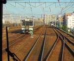 Serie 213: Ausserhalb des Bahnhofs Nagoya wartet ein JR Tôkai-Zug mit dem Wagenpaar KUMOHA 213-5003 + Steuerwagen KUHA 212-5003 an der Spitze in einem Abstellgleis. 25.September 2009. (Aufnahme durch die verglaste Führerstandrückwand eines Gegenzugs)