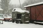 Kemence Museumbahn The P2 locomotive in sleeping in the snow at Kemence station. In the bacground there is a renewed freight wagon.
