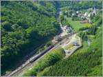 Dies ist keine Luftaufnahme, sondern die Aussicht von dem Silikatfelsen  Hockslay  auf den Bahnhof von Kautenbach mit dem einfahrenden IR Luxemburg-Liers.