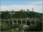 Im Bereich der Stadt Luxemburg gibt es vier Viadukte, sie sind die imposantesten Bauwerke der luxemburgischen Eisenbahn. Auf diesem Bild sieht man den IR Luxemburg-Liers auf dem Pfaffentaler Viadukt, welcher mit seinen 257 Metern der längste Viadukt ist.
Im Hintergrund ist das Kontrastprogramm der Stadt Luxemburg zu sehen: links Überreste der Festung und rechts das moderne Centre Européen. 01.08.09 (Jeanny) 