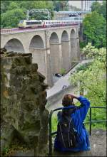 . Der Bahnfotograf und sein Sujet - Am Plateau du Rham (op der Rumm) in Luxemburg Stadt mitten in den Überresten der ehemaligen Festung bieten sich tolle Möglichkeiten die Züge auf dem Pulvermühle Viadukt (Biisser Bréck) abzulichten. 

Der fitte und sportliche Fotograf hatte es sich am 14.06.2013 auf einem Felsvorsprung gemütlich gemacht, als der IR 116 Luxembourg - Liers, gezogen von der schmutzigen 3006, über die Brücke fuhr. (Jeanny)
